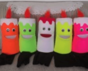 Colorful, playful candle decorations with faces and vibrant tops, lined up on a surface. Perfect for festive displays or children's events.
