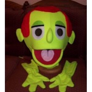 Bright green puppet head with red hair and large eyes, displayed on a brown surface. Ideal for children's performances or educational activities.